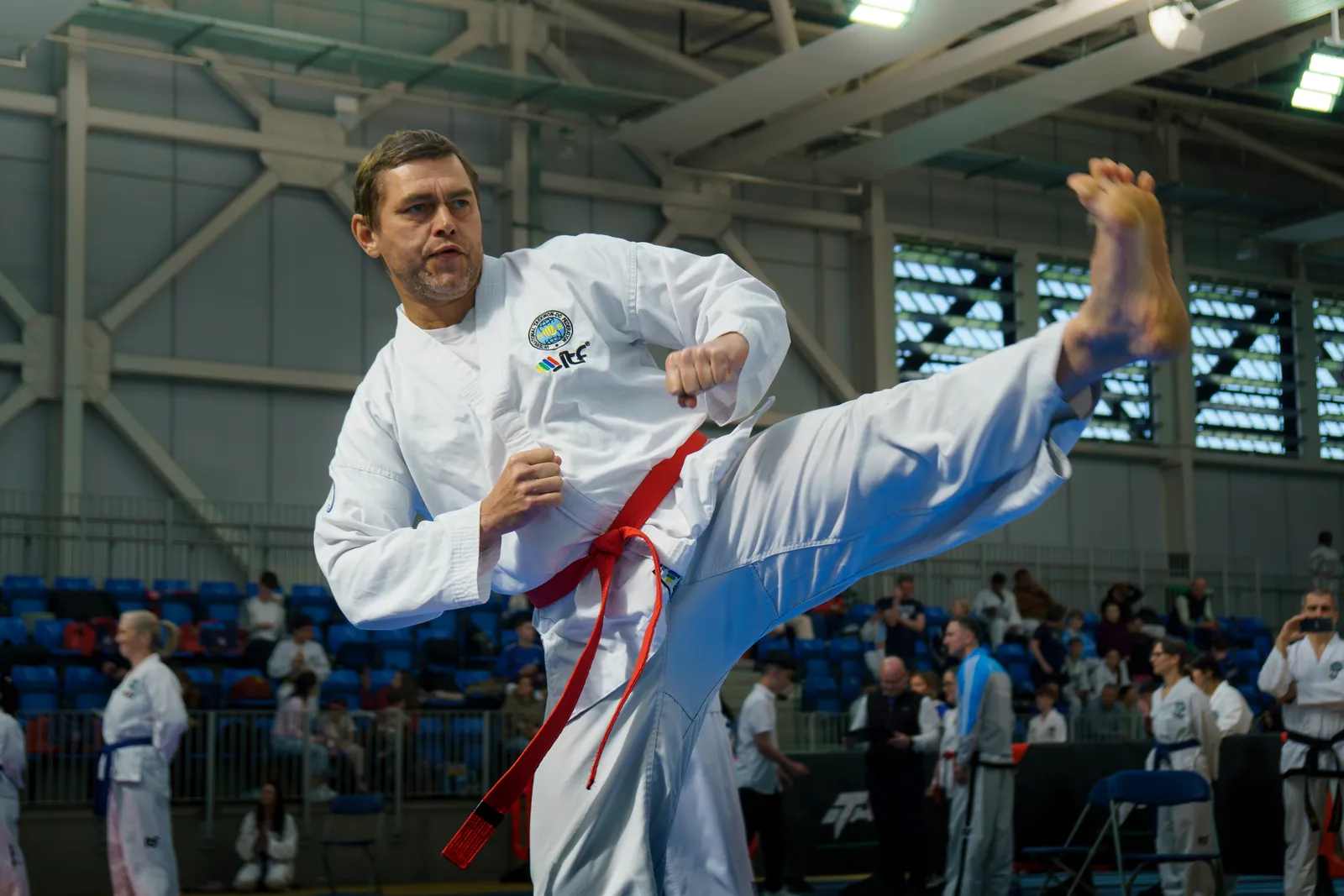 Adult ITF Taekwon-Do practitioner performing a high side kick