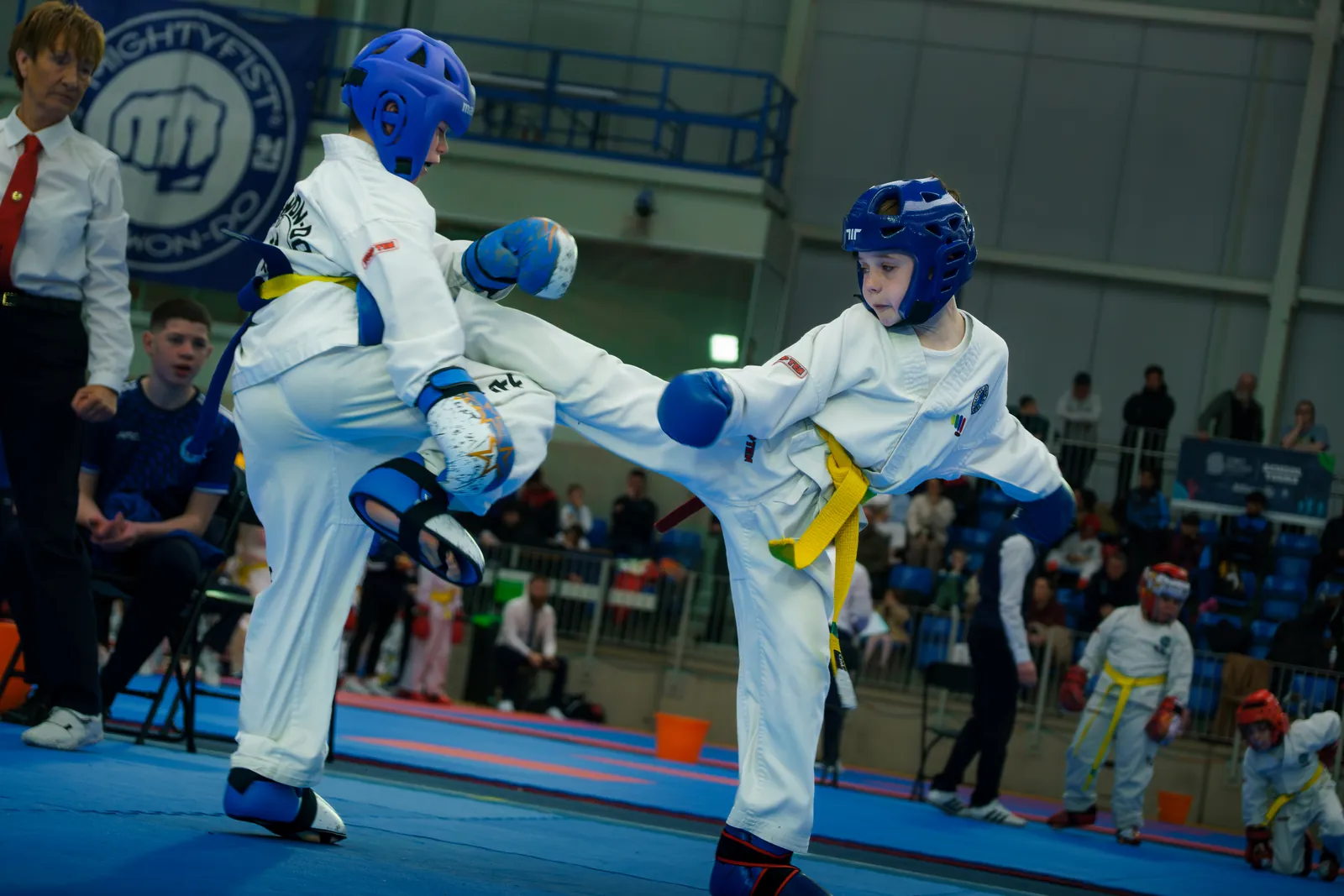 Two junior competitors sparring in protective equipment