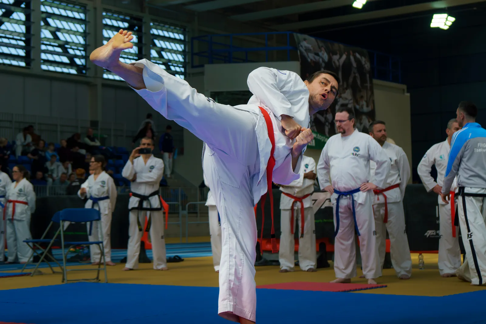 Adult practitioner extending a turning kick during a pattern performance