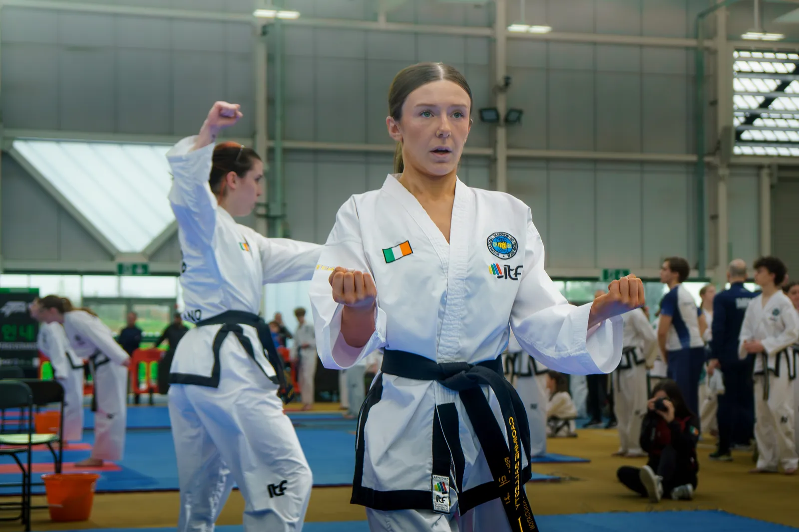 Black belt athlete holding a guarding stance during a pattern